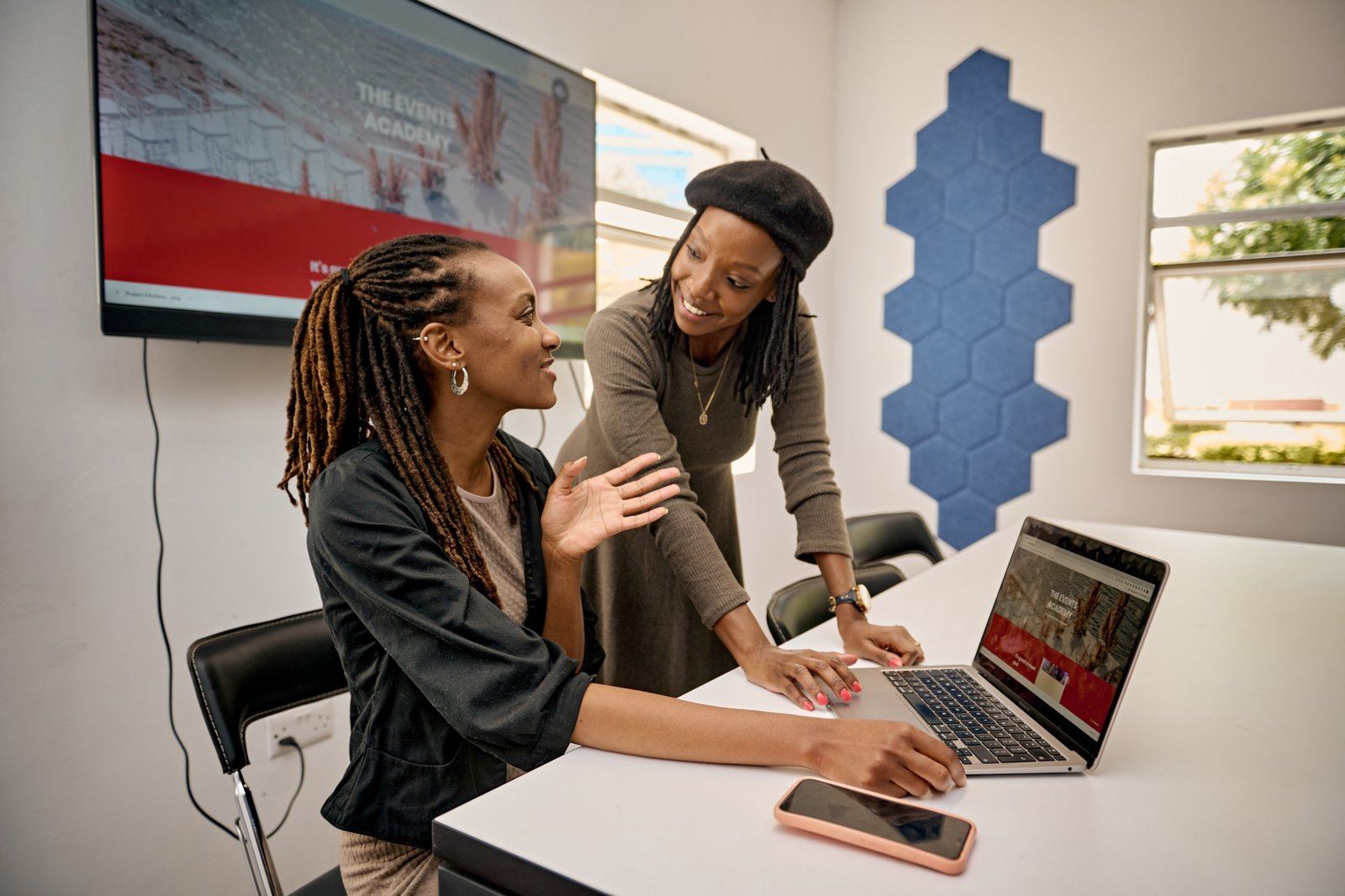 A trainer and a student reviewing work together on a laptop